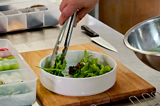 Листья салата выкладываются на тарелку.